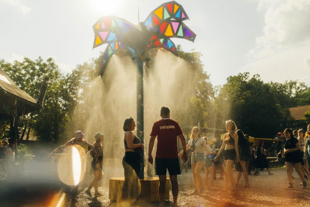 Bild von Besuchern unter Wassernebel beim PULS OPEN AIR
